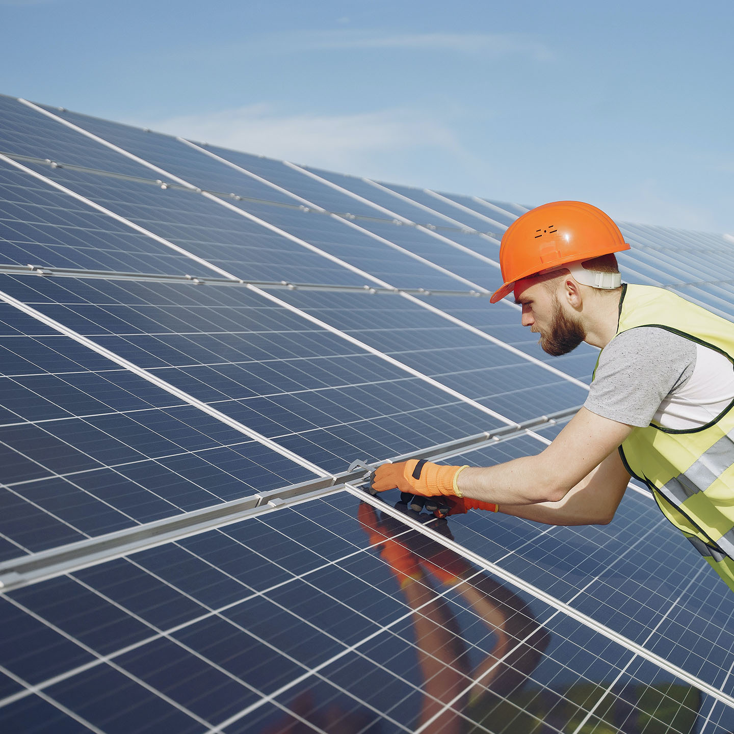 Fachkraft bei der Anbringung einer Photovoltaikanlage auf dem Dach