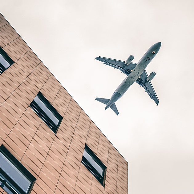 Flugzeug über moderner Gebäudefassade